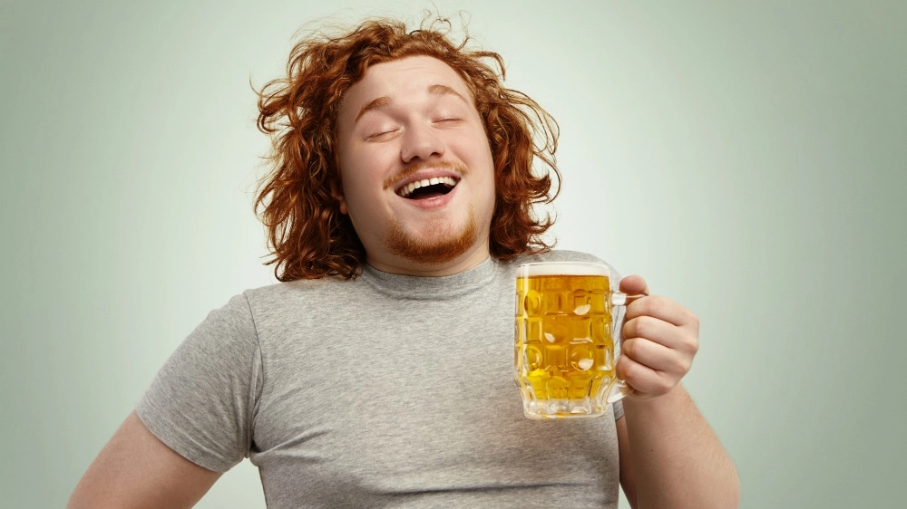 funny-young-caucasian-male-feeling-happy-relaxed-anticipating-fresh-cold-beer-his-hands-after-hard-working-day-closing-eyes-enjoyment-bearded-overweight-redhead-man-drinking-lager