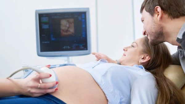 Loving couple attending doctor for pregnancy ultra sound procedu