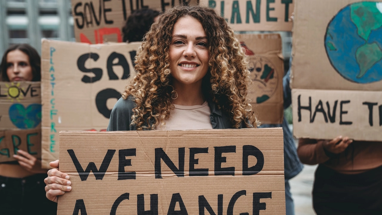 A group of young adult people are marching together on strike against climate change