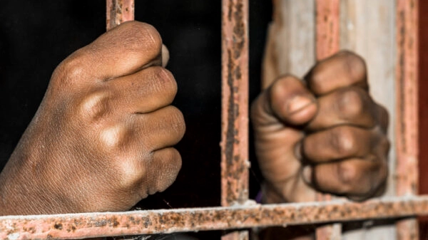 closeup of brown hands of prison inside the jail