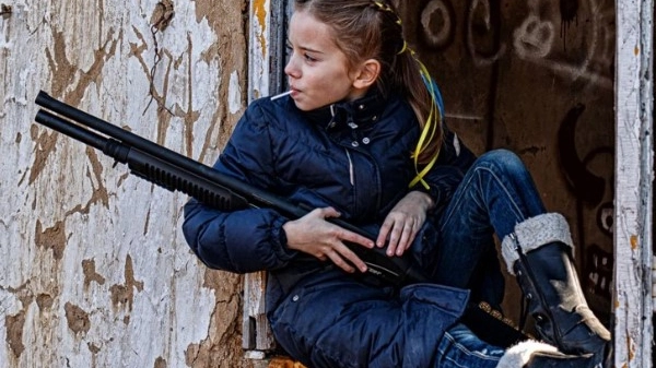 La bambina ucraina con lecca lecca e fucile