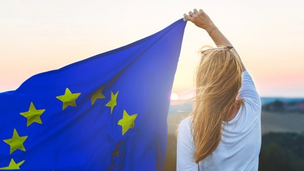 Happy woman and waving EU flag. Symbol of freedom.