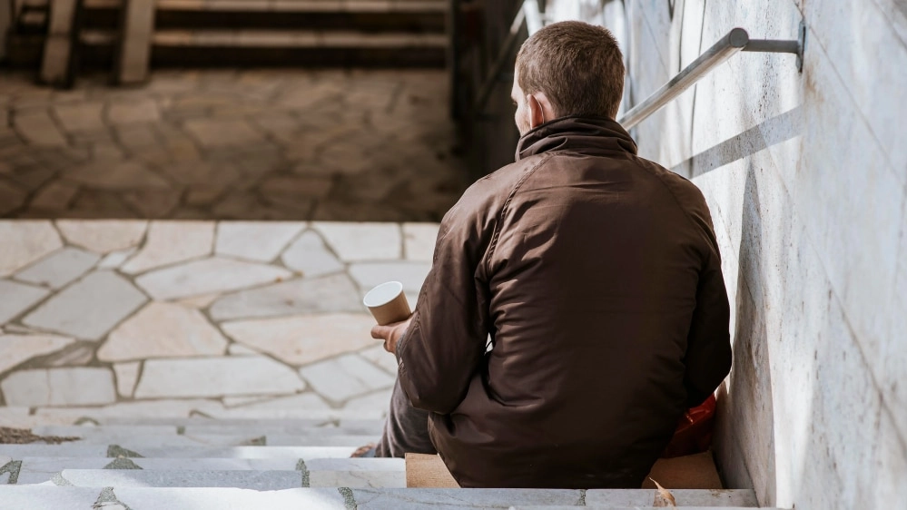 back-view-homeless-man-with-cup-stairs