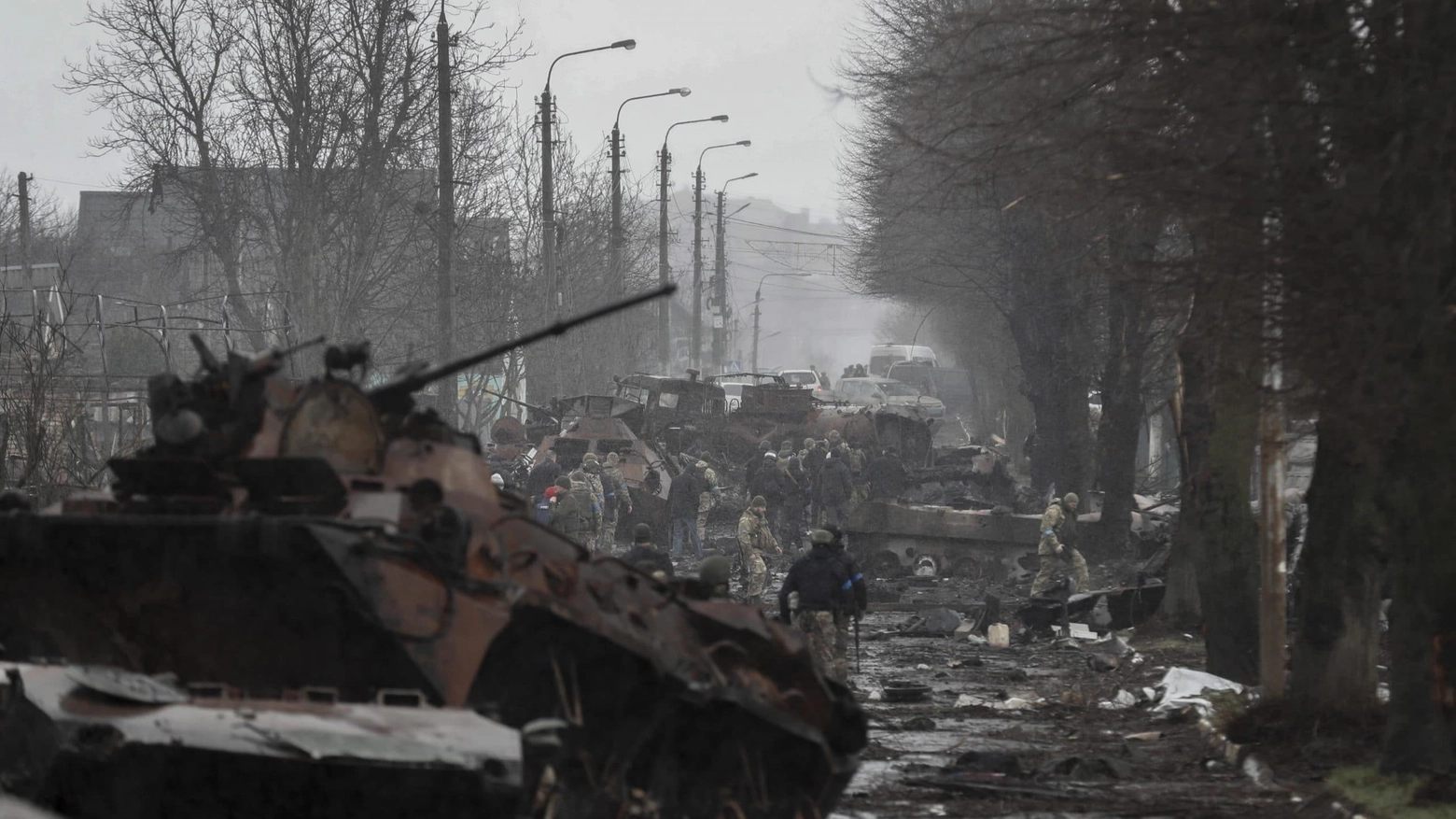 Soldati ucraini ispezionano un convoglio di carri armati russi distrutti a Bucha, Ucraina (Foto Ansa / EPA / Atef Safadi)