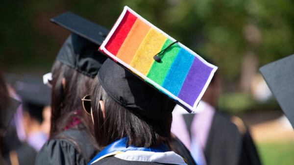 Woman Wears Graduation Cap and Gown Showing Gay Pride