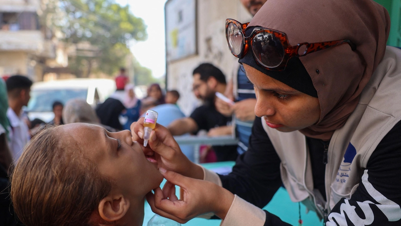 Un'operatrice sanitaria somministra il vaccino antipolio a un bambino palestinese a Zawayda, nella Striscia di Gaza centrale (Foto di Eyad BABA / AFP)