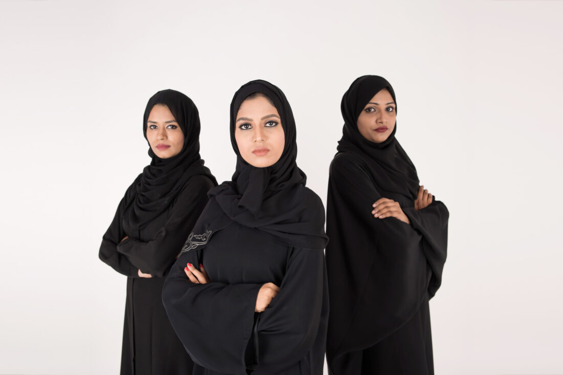 Arab women in traditional dress standing on white background