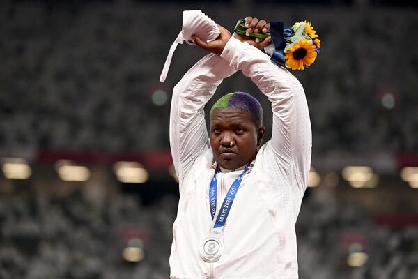 Second-placed USA's Raven Saunders celebrates on the podium with her silver medal after wining the women's shot put event during the Tokyo 2020 Olympic Games at the Olympic Stadium in Tokyo on August 1, 2021. (Photo by Ina FASSBENDER / AFP)