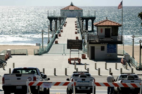 MANHATTAN BEACH, CALIFORNIA - MARCH 27: Police cars are stationed in front of the closed pier and beach amid the coronavirus pandemic on March 27, 2020 in Manhattan Beach, California. Los Angeles County closed all beaches today as a new measure to stem the spread of COVID-19.   Mario Tama/Getty Images/AFP
== FOR NEWSPAPERS, INTERNET, TELCOS & TELEVISION USE ONLY ==