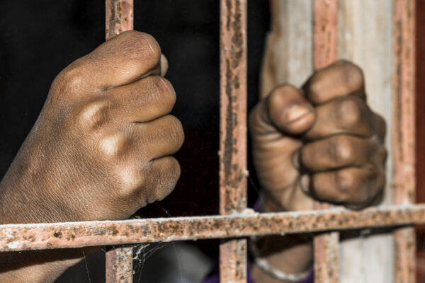 closeup of brown hands of prison inside the jail