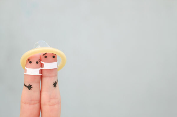Fingers art of Happy couple in medical mask from COVID-2019. Concept of safe sex.