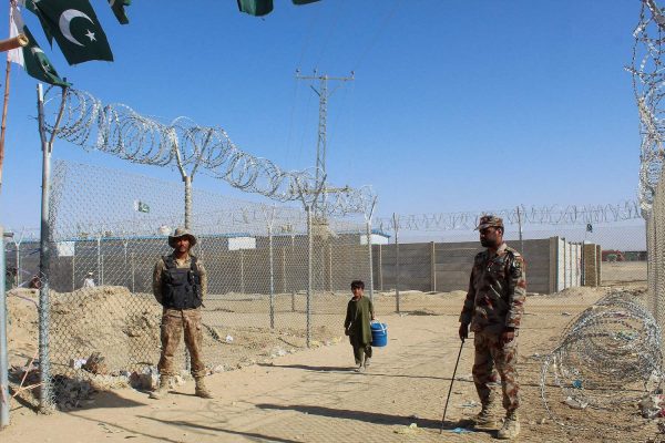 A Afghan boy walks by the fences guarded by the Pakistani paramilitary personnel at the Pakistan-Afghanistan border crossing point in Chaman on August 23, 2021 following Taliban's military takeover of Afghanistan. (Photo by - / AFP)