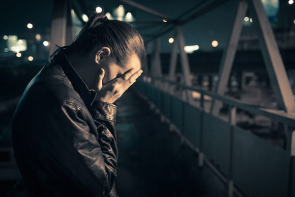 Woman crying on the bridge at night.