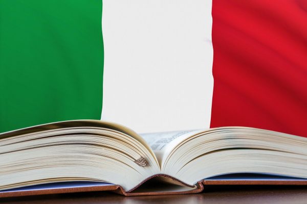 Education in Italy. Opened book and national flag on background.