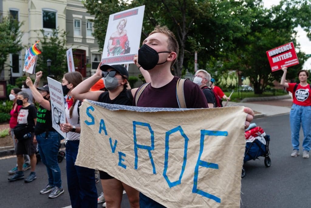 Un dimostrante a favore dell'aborto tiene uno striscione mentre marcia verso la Corte Suprema a Washington