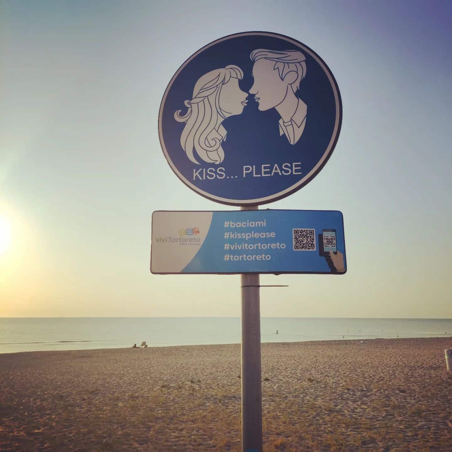 Il cartello con l'obbligo di baciarsi sul lungomare di Tortoreto (Instagram)