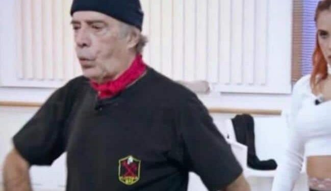 Enrico Montesano con una maglietta nera con il simbolo della Decima Mas