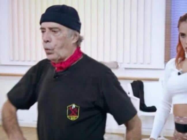 Enrico Montesano con una maglietta nera con il simbolo della Decima Mas