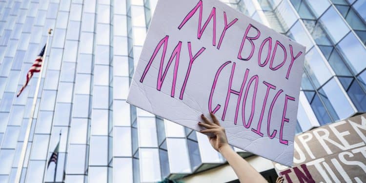 Un manifestante per i diritti dell'aborto regge un cartello con la scritta "Il mio corpo, la mia scelta" davanti alla Corte federale di giustizia