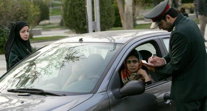 La polizia iraniana controlla i documenti di una donna ad un posto di blocco